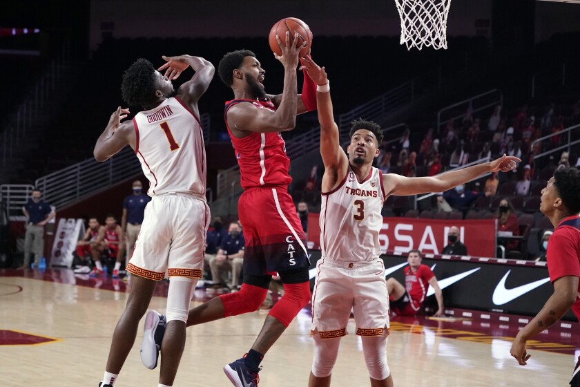 Arizona's Jordan Brown goes up for a shot between USC's Chevez Goodwin, left, and Isaiah Mobley on Feb. 20, 2021.