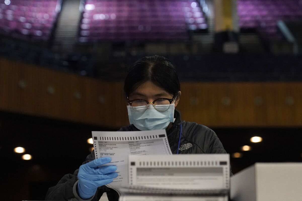 San Francisco Department of Elections worker Rosy Chan checks for damaged ballots at a voting center in San Francisco, Sunday, Nov. 1, 2020. (AP Photo/Jeff Chiu)