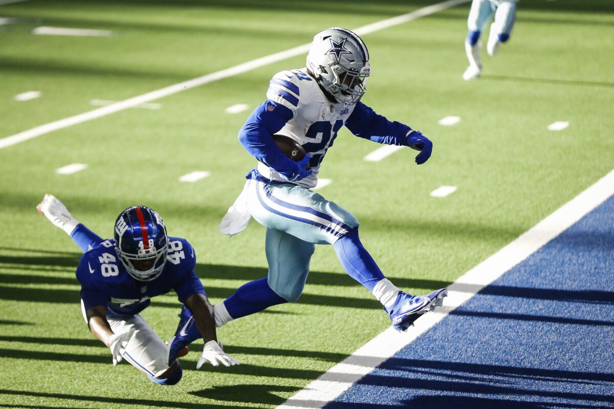 Cowboys Ezekiel Elliott leaps out of the way to a touchdown during the game against New York Giants Sunday, Oct. 11, 2020, in Arlington, Texas. (Yffy Yossifor/Star-Telegram via AP)