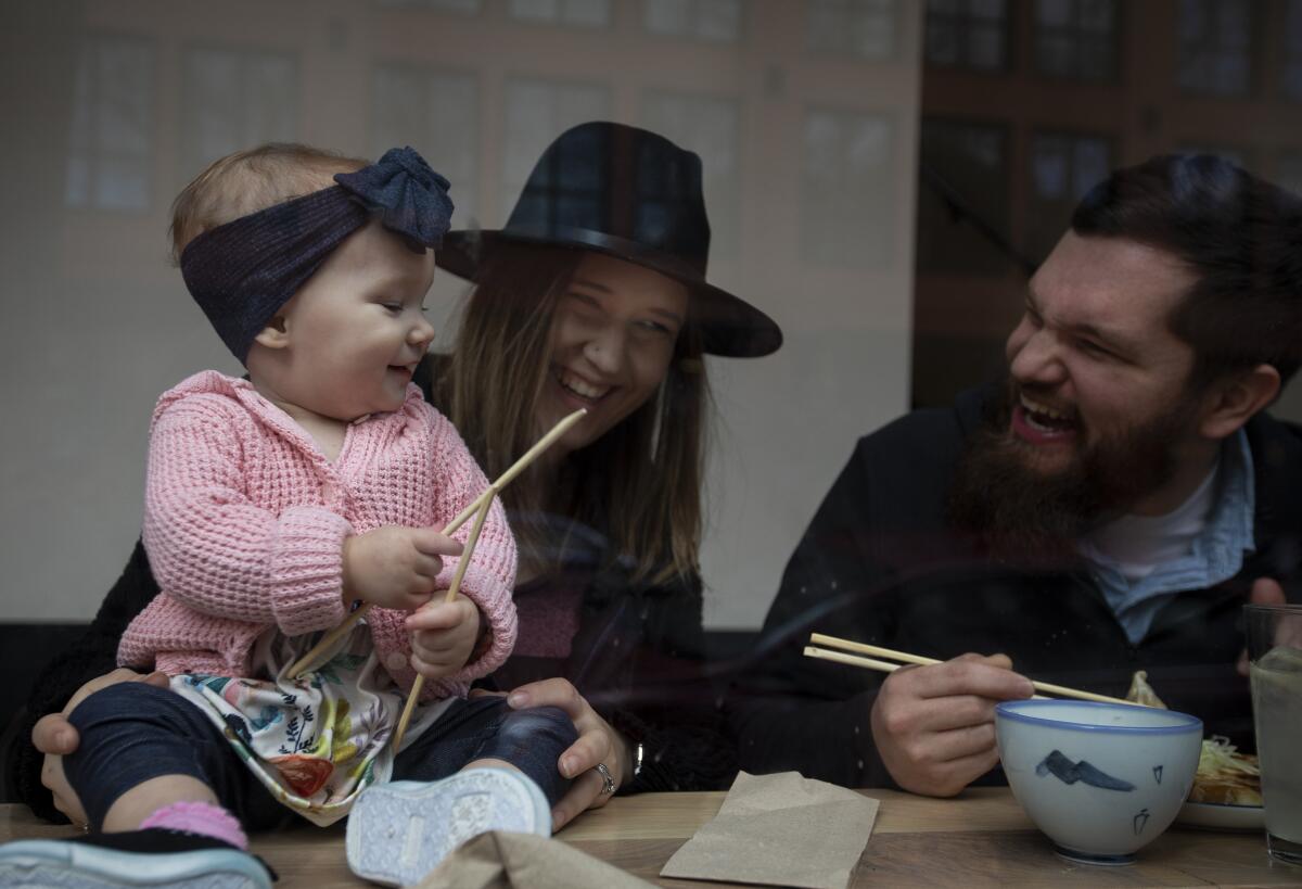 Everlyn Jorgenson, left, gets smiles from her parents, Emilie and Keaton Jorgenson, as they eat lunch at Afuri Ramen + Dumpling in Portland, Ore.