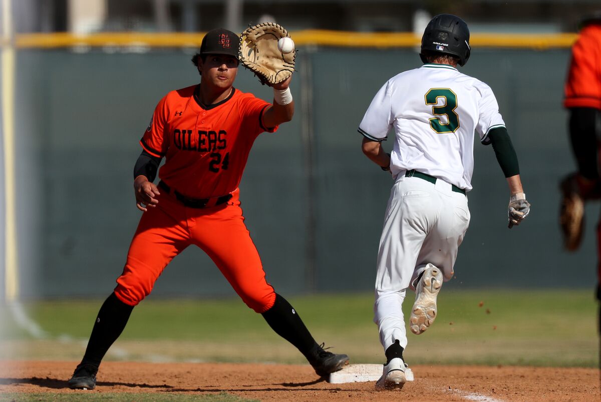 Huntington Beach's Ralph Velazquez (24) secures an out at first base against Edison during a Surf League opener.