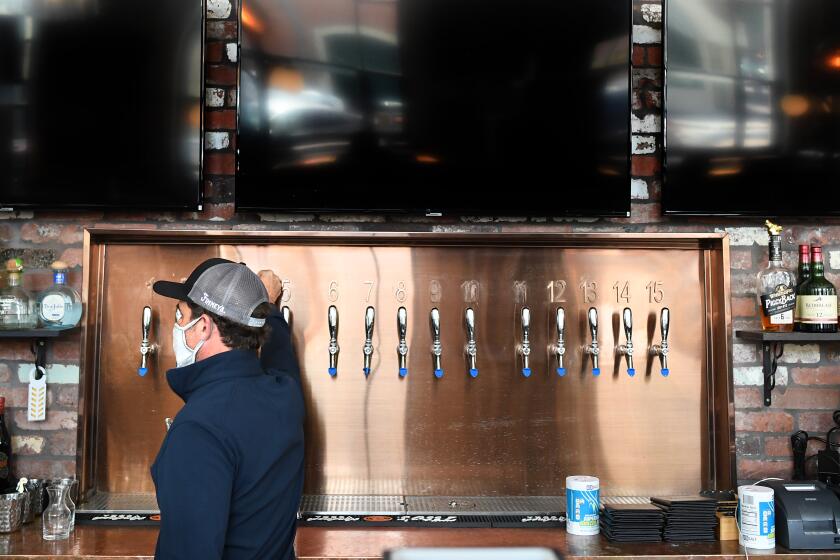 VENTURA, CALIFORNIA MAY 23, 2020-An employee at Finney's Crafthouse prepares the bar to open Thursday in Ventura Saturday. The county lifted a lockdown for sit down dining at all restaurants.(Wally Skalij/Los Angeles Times)