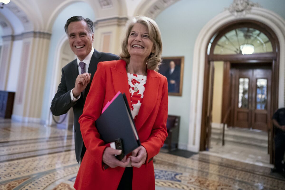 FILE - Republican Sens. Lisa Murkowski, of Alaska, and Mitt Romney of Utah, left, who say they will vote to confirm Judge Ketanji Brown Jackson's historic nomination to the Supreme Court, smile as they greet each other outside the chamber, at the Capitol in Washington, Tuesday, April 5, 2022. Murkowski continues to have a substantial cash advantage over her opponent backed by former President Donald Trump, who has vowed revenge on the incumbent Alaska Republican. Murkowski brought in more than $1.5 million in the three-month period ending March 31, 2022, according to Federal Election Commission filings. (AP Photo/J. Scott Applewhite, File)