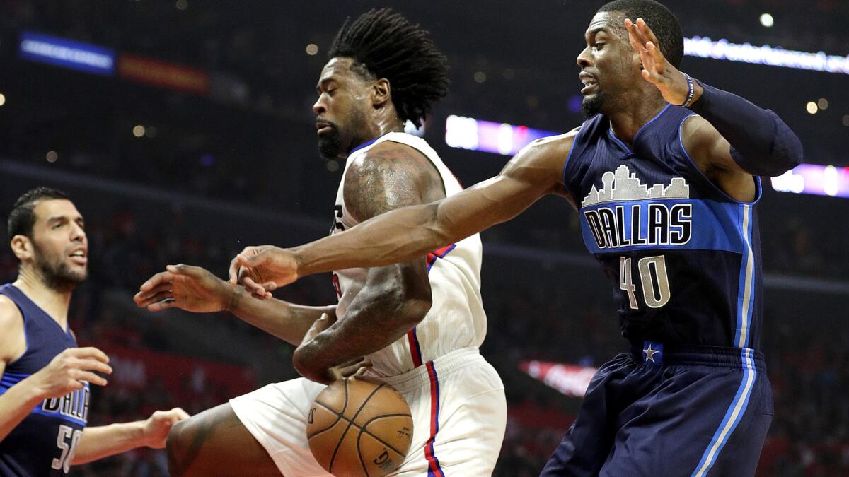 Clippers center DeAndre Jordan tries to grab a rebound while under pressure from Mavericks forward Harrison Barnes during the first half Friday night.