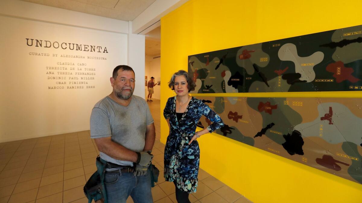 Artist Marcos Ramirez ERRE and curator Alessandra Moctezuma stand before one of the artist's works in "Undocumenta."