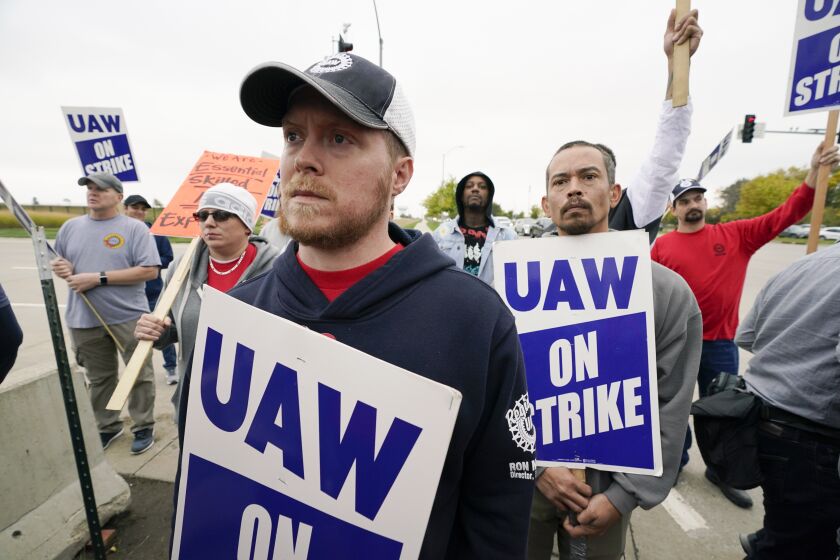 Members of the United Auto Workers listen to Agriculture Secretary Tom Vilsack speak outside of a John Deere plant, Wednesday, Oct. 20, 2021, in Ankeny, Iowa. About 10,000 UAW workers have gone on strike against John Deere since last Thursday at plants in Iowa, Illinois and Kansas. (AP Photo/Charlie Neibergall)