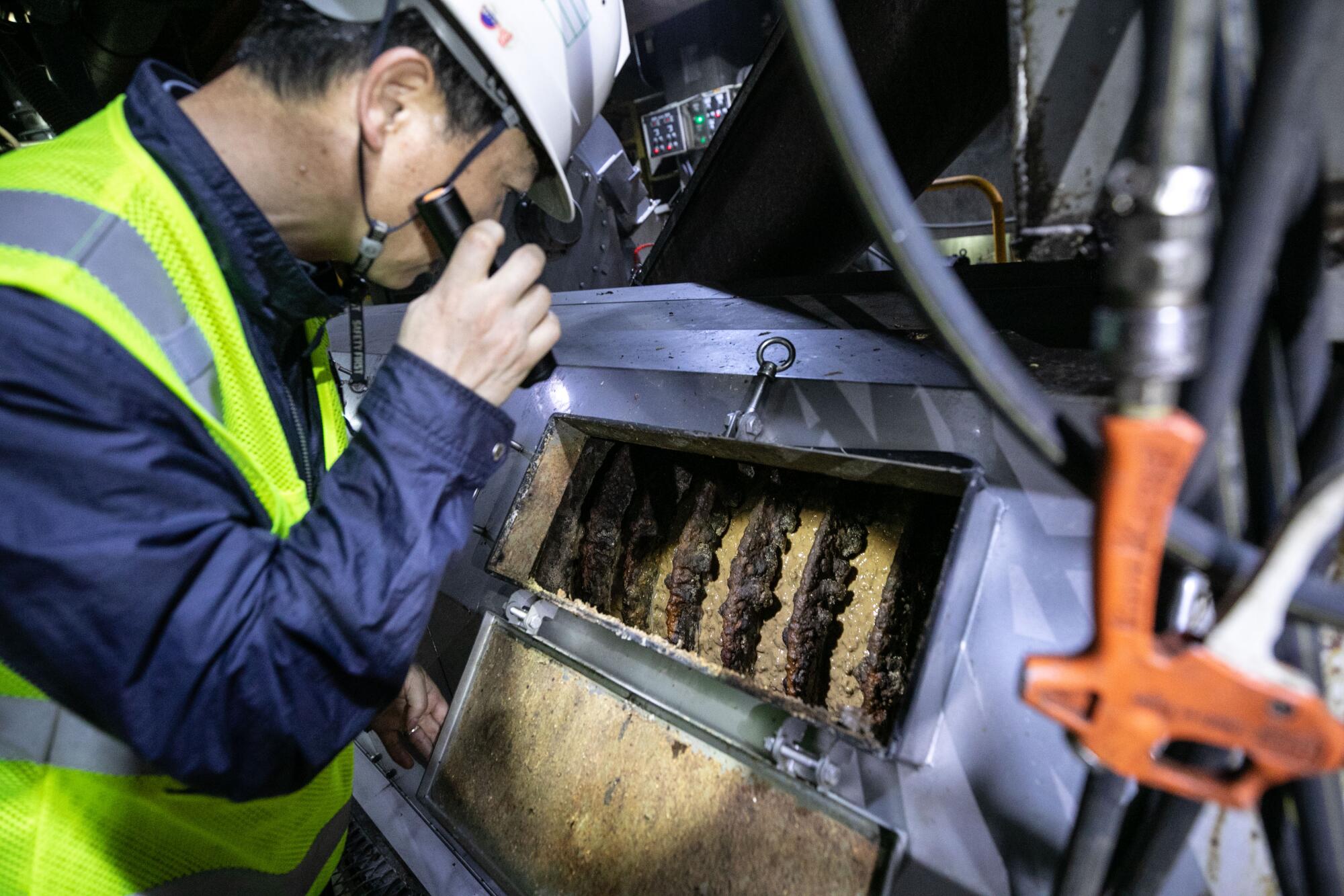 Choi Jae-guk checks out the sludge machine for dewatering of the food waste.