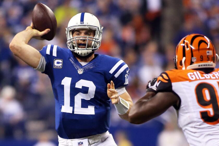 Indianapolis Colts quarterback Andrew Luck, left, throws in front of Cincinnati Bengals defensive end Wallace Gilberry during the Colts' 26-10 AFC wild-card win Sunday.