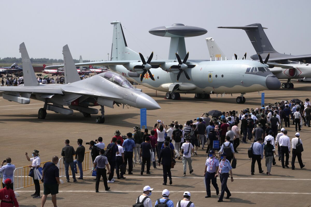 Visitors view the Chinese military's J-16D electronic warfare airplane, left, and the KJ-500 airborne early warning and control aircraft at right during 13th China International Aviation and Aerospace Exhibition, also known as Airshow China 2021, Wednesday, Sept. 29, 2021, in Zhuhai in southern China's Guangdong province. With record numbers of military flights near Taiwan over the last week, China has been stepping up its harassment of the island it claims as its own, showing an new intensity and sophistication as it asserts its territorial claims in the region. (AP Photo/Ng Han Guan)