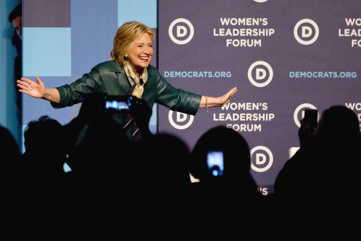 Democratic presidential candidate and former Secretary of State Hillary Rodham Clinton bows toward the cheering crowd after speaking to the Democratic National Committee 22nd Annual Women's Leadership Forum National Issues Conference in Washington, Friday, Oct. 23, 2015. Peeking onto stage at left is Clinton's traveling press secretary Nick Merrill. (AP Photo/Jacquelyn Martin)