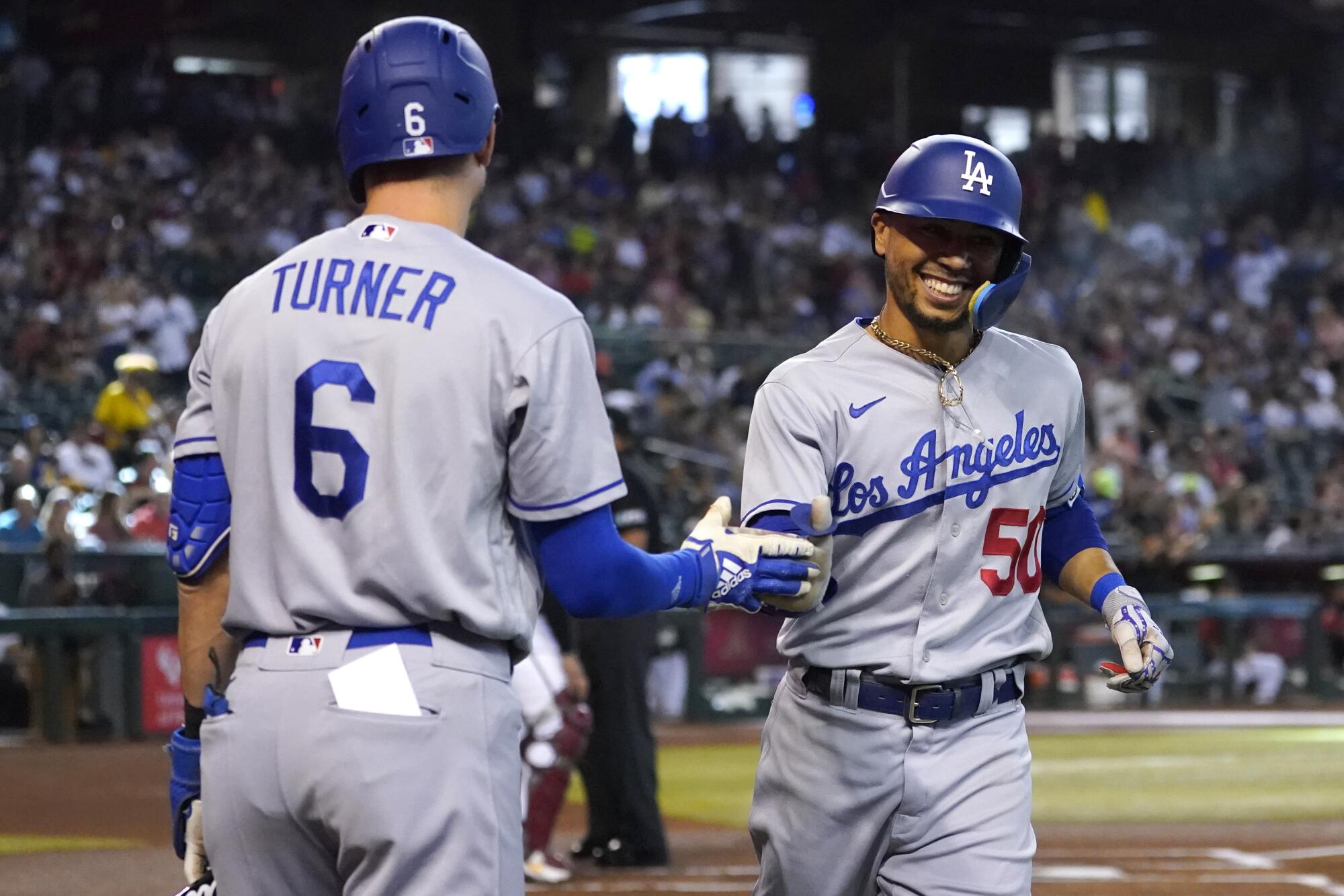 Mookie Betts celebrates with Dodgers teammate Trea Turner after hitting a first-inning solo home run.