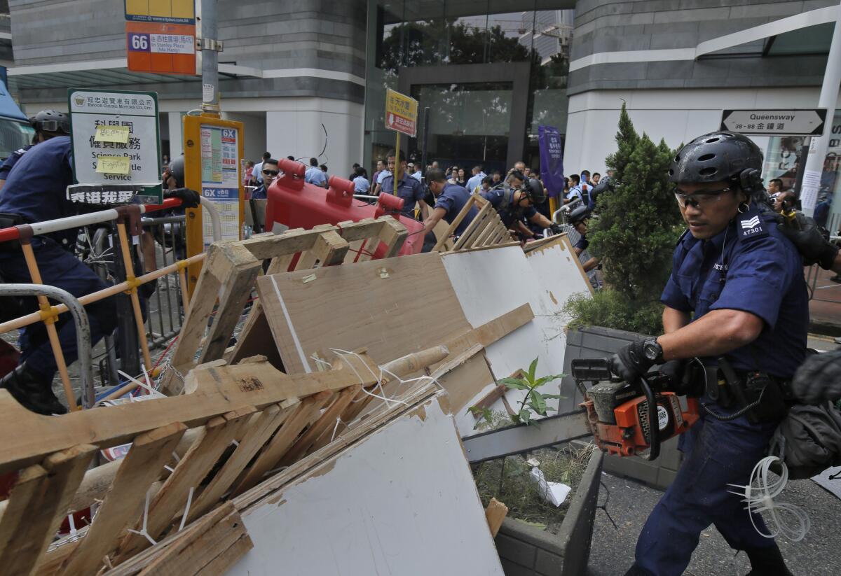Police remove barricades that protesters set up to block off main roads in the Central district of Hong Kong on Oct. 14.