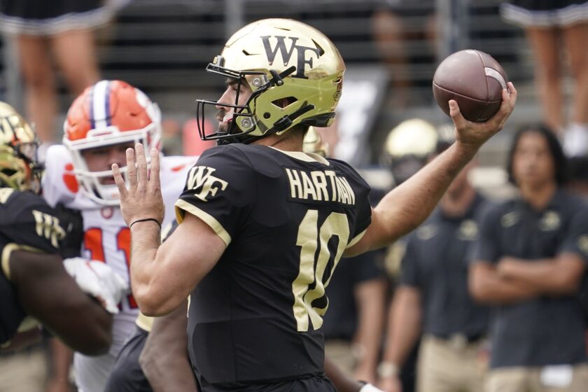 Wake Forest quarterback Sam Hartman (10) looks to pass against Clemson during the first half of an NCAA college football game in Winston-Salem, N.C., Saturday, Sept. 24, 2022. (AP Photo/Chuck Burton)
