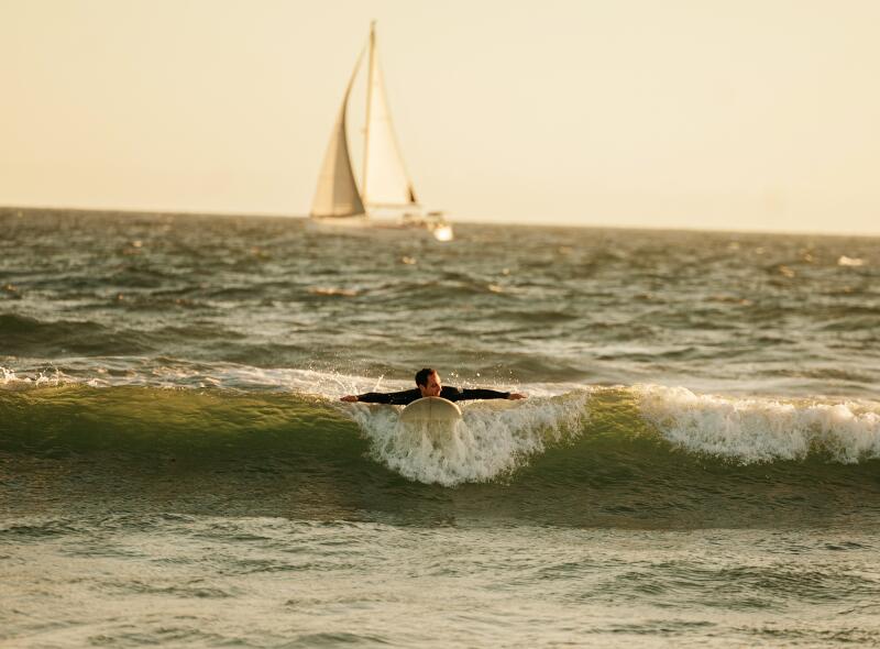Venice, CA - April 03: A man surfs at Venice Beach on Wednesday, April 3, 2024 in Venice, CA. (Jason Armond / Los Angeles Times)