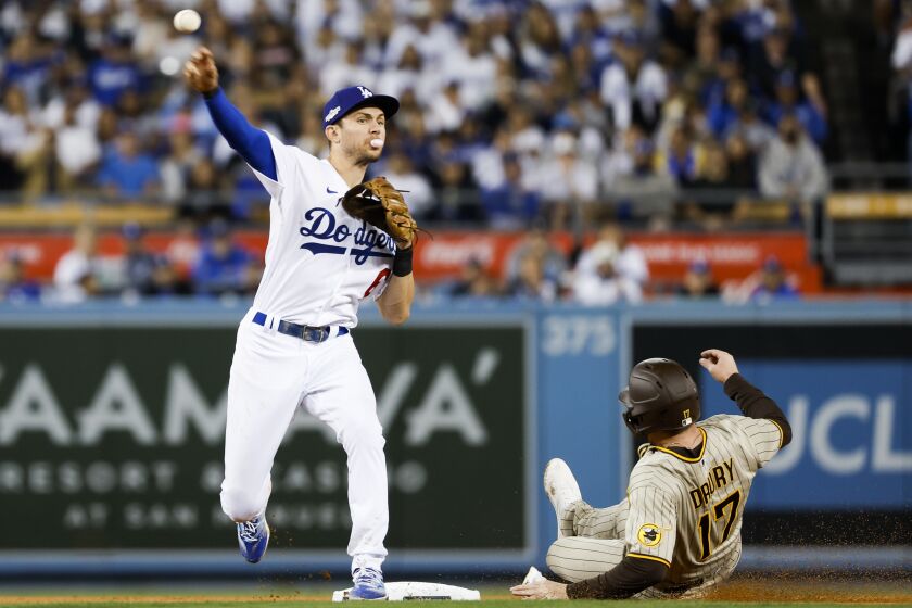 Los Angeles, CA - October 12: Los Angeles Dodgers shortstop Trea Turner, left, throws to first after forcing out San Diego Padres' Brandon Drury during the sixth inning in game two of the NLDS at Dodger Stadium on Wednesday, Oct. 12, 2022 in Los Angeles, CA.(K.C. Alfred / The San Diego Union-Tribune)