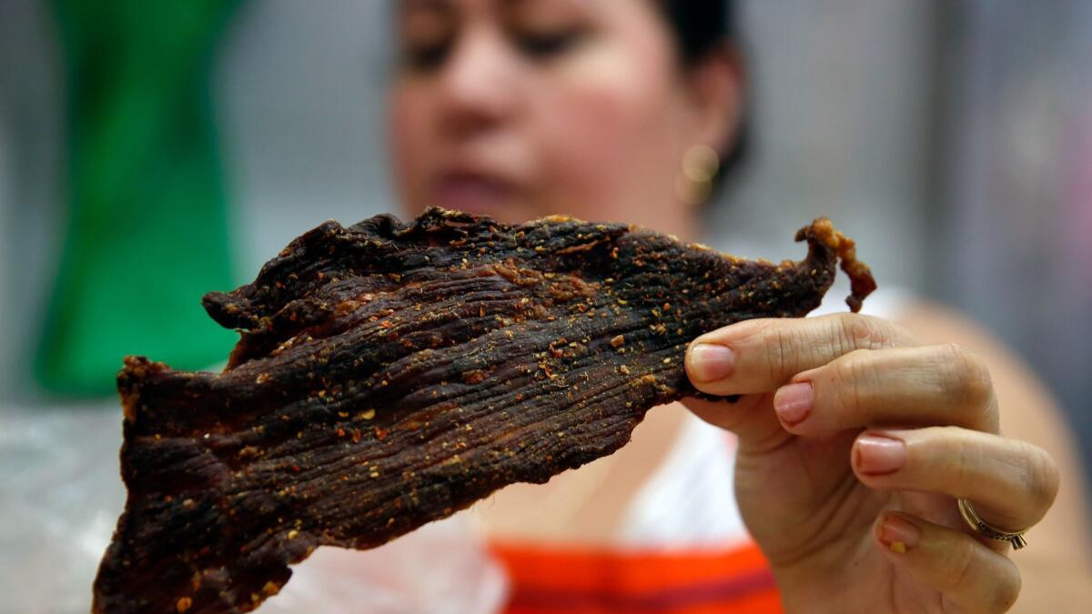 Carla Viega holds a piece of dried beef with chile at Carniceria Las Gueritas Arzate at the Mercado Municipal in Hermosillo, Mexico.