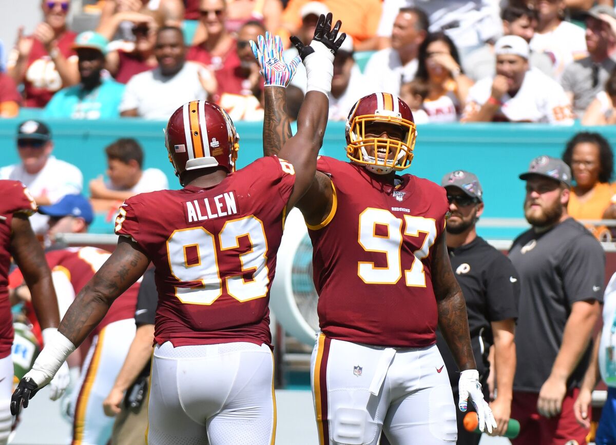 Washington Redskins teammates Tim Settle, right, and Jonathan Allen celebrate after sacking Miami Dolphins quarterback Josh Rosen on Sunday.