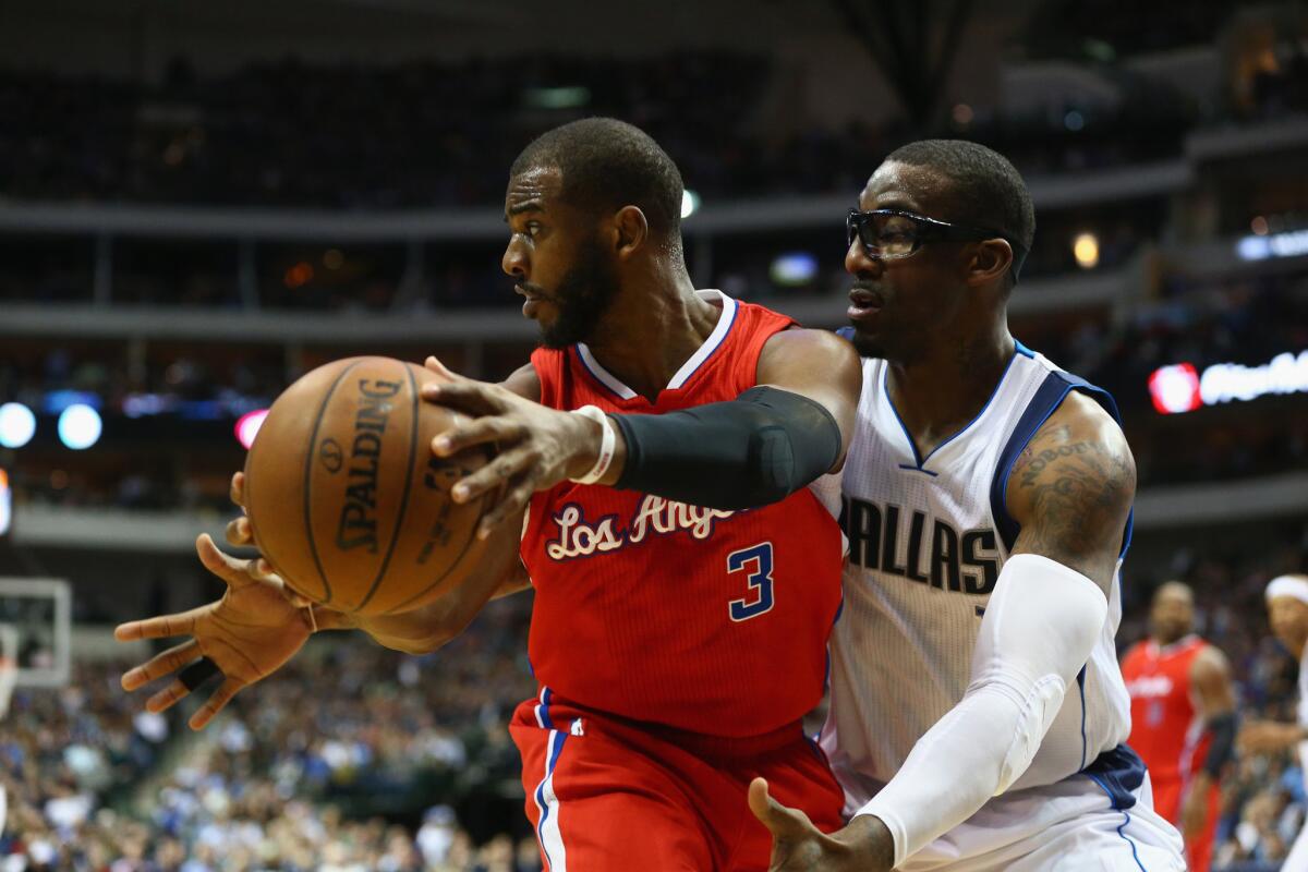 Clippers point guard Chris Paul looks for a teammate as he's defended by Mavericks center Amare Stoudemire in the first half.