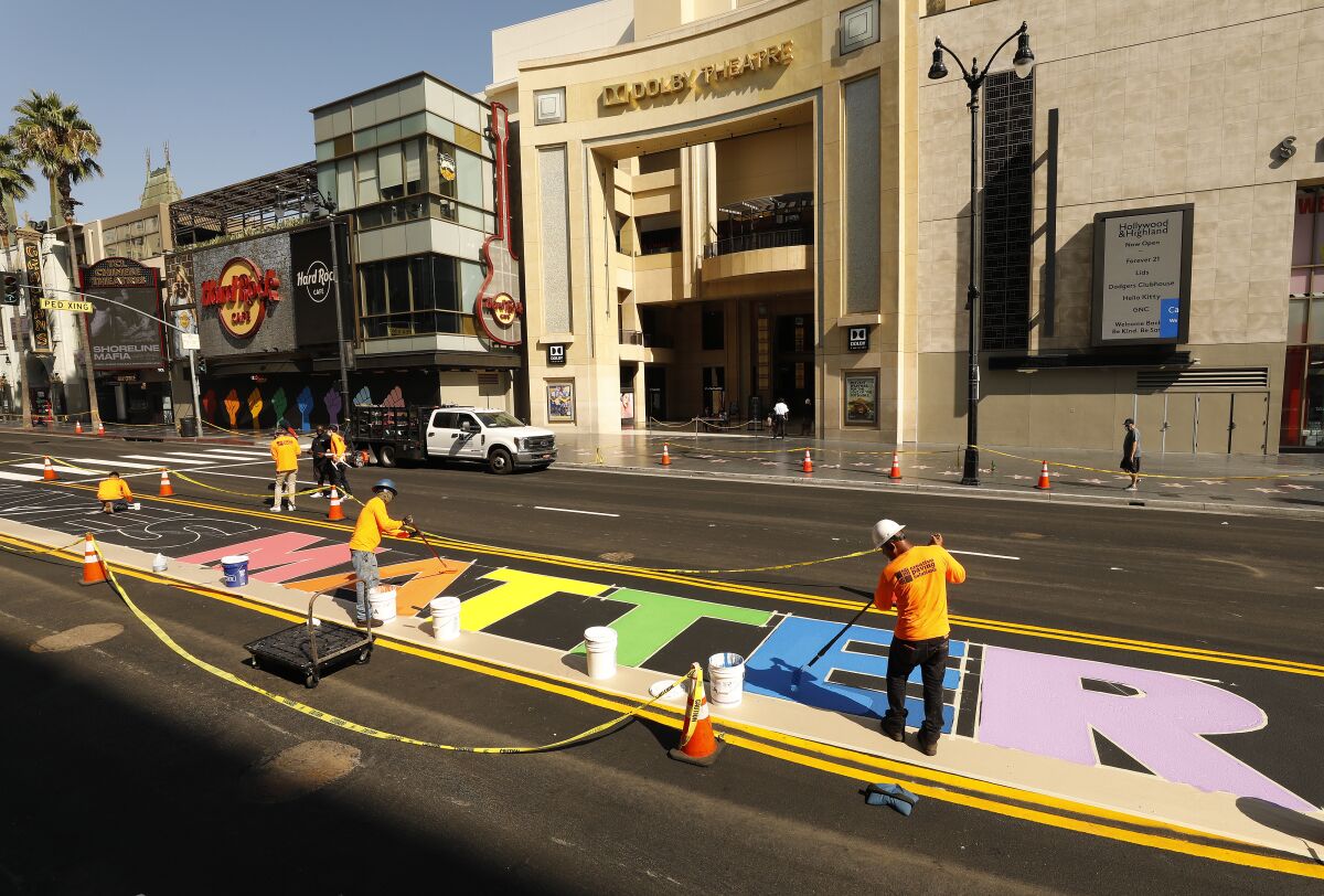 Crews begin to paint the colors on the permanent 'All Black Lives Matter' street mural in the middle of Hollywood Blvd.
