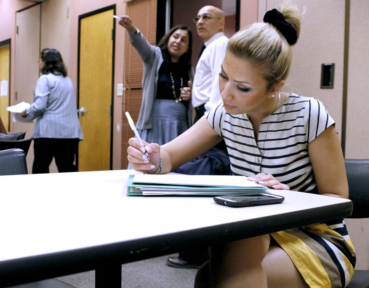 Masha Khodabakhshi, 34 of Woodland Hills, fills out a Vons job application at the Verdugo Jobs Center in Glendale during the summer