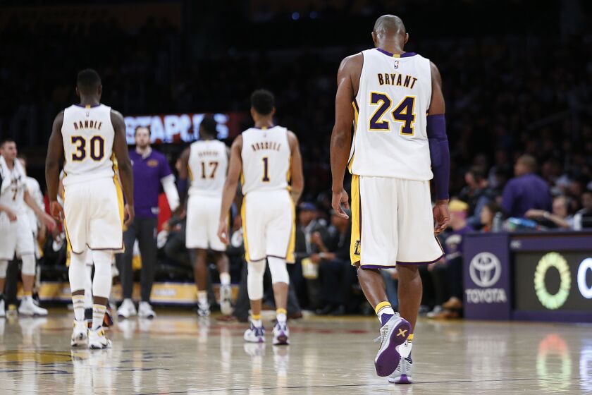 Lakers forward Kobe Bryant walks off the court with teammates during a timeout Sunday.