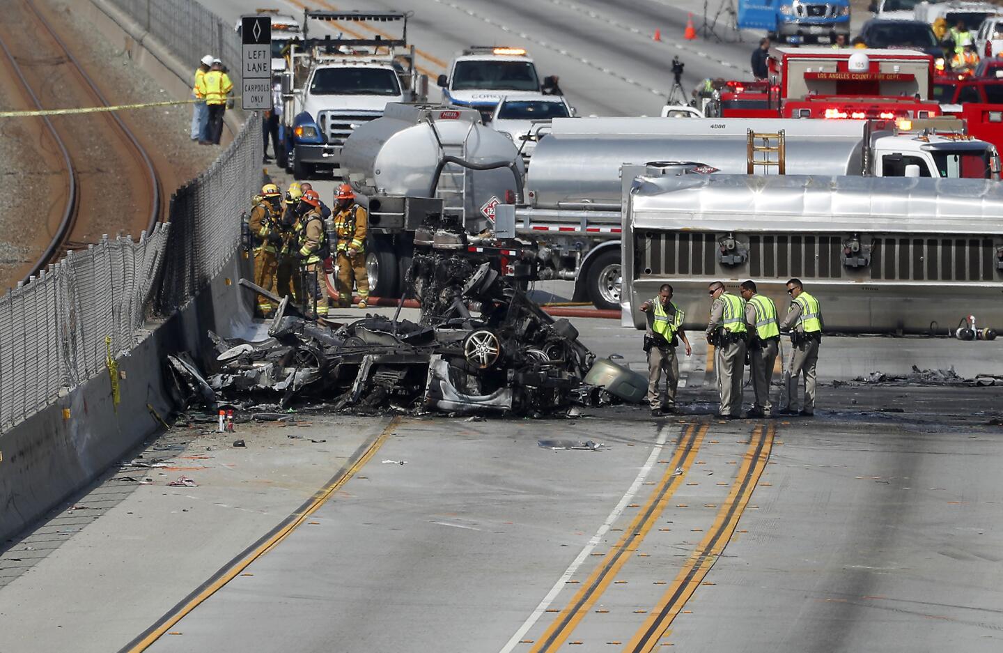 Los Angeles County Firefighters and CHP officers at the scene of a deadly accident involving a tanker truck and a Range Rover on the westbound 105 Freeway near Prairie Ave. in Hawthorne.