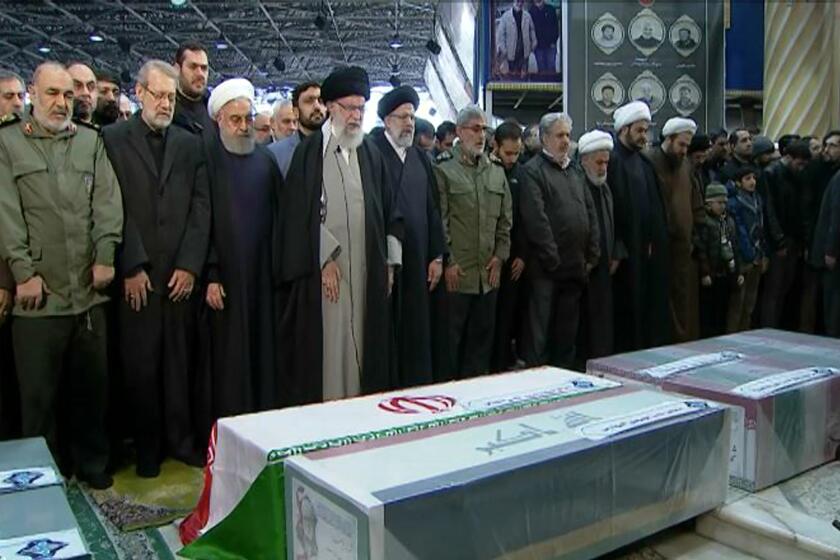 FILE- In this photo released by the official website of the Office of the Iranian Supreme Leader, supreme leader Ayatollah Ali Khamenei, front row, fourth from left, leads a prayer over the coffins of Gen. Qassem Soleimani and his comrades, who were killed in Iraq in a U.S. drone strike on Friday, at the Tehran University campus, in Tehran, Iran, Monday, Jan. 6, 2020. (Office of the Iranian Supreme Leader via AP, File)