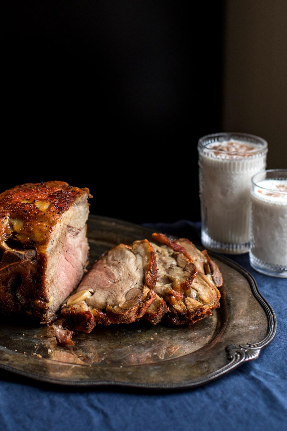 Pernil served with a side of coquito, a Puerto Rican version of eggnog made with coconut milk, coconut cream and evaporated milk