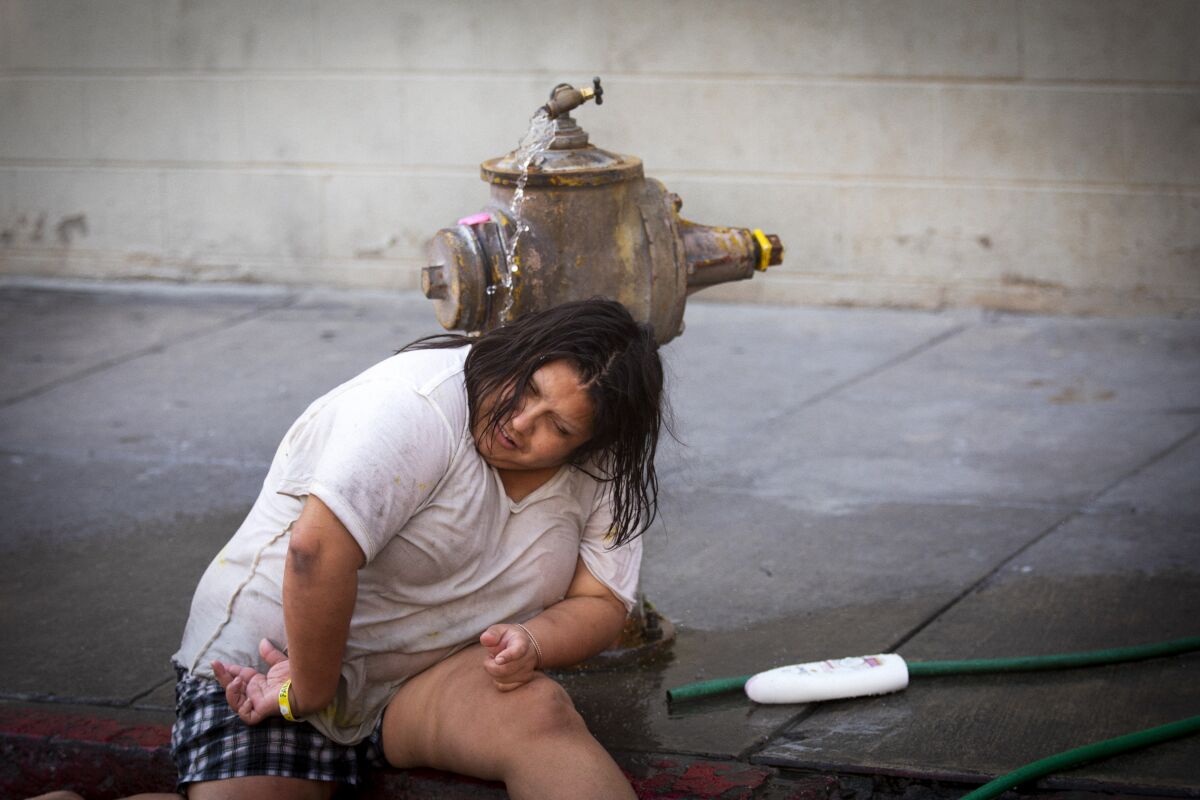 Monica Ruiz, 32, cools down in the water from a fire hydrant on Crocker Street in downtown L.A. on Sept. 6.