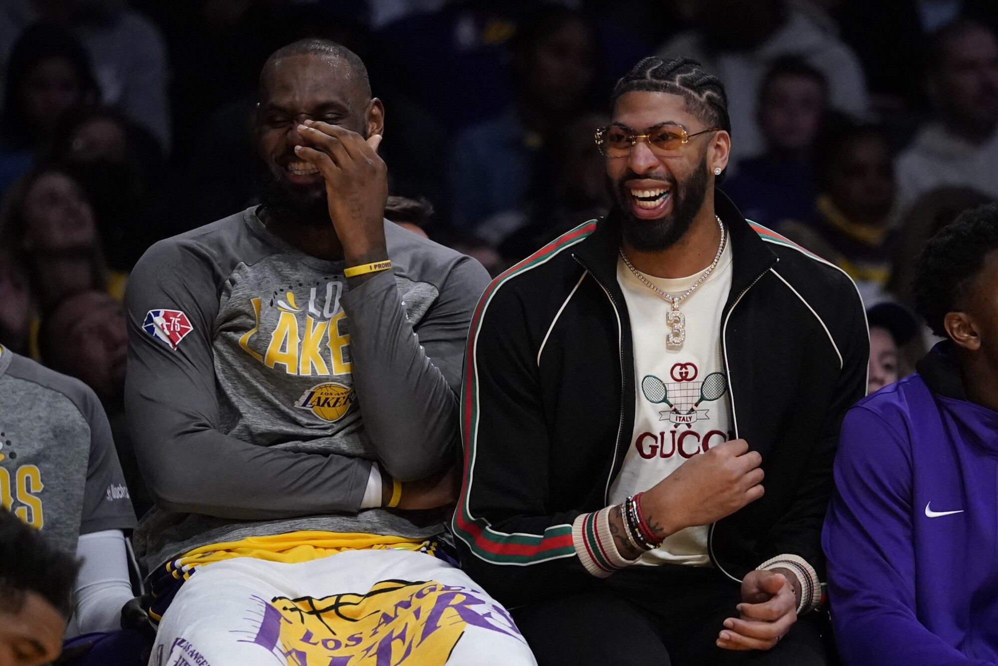 Lakers forwards LeBron James, left, and Anthony Davis share a laugh while sitting on the bench.