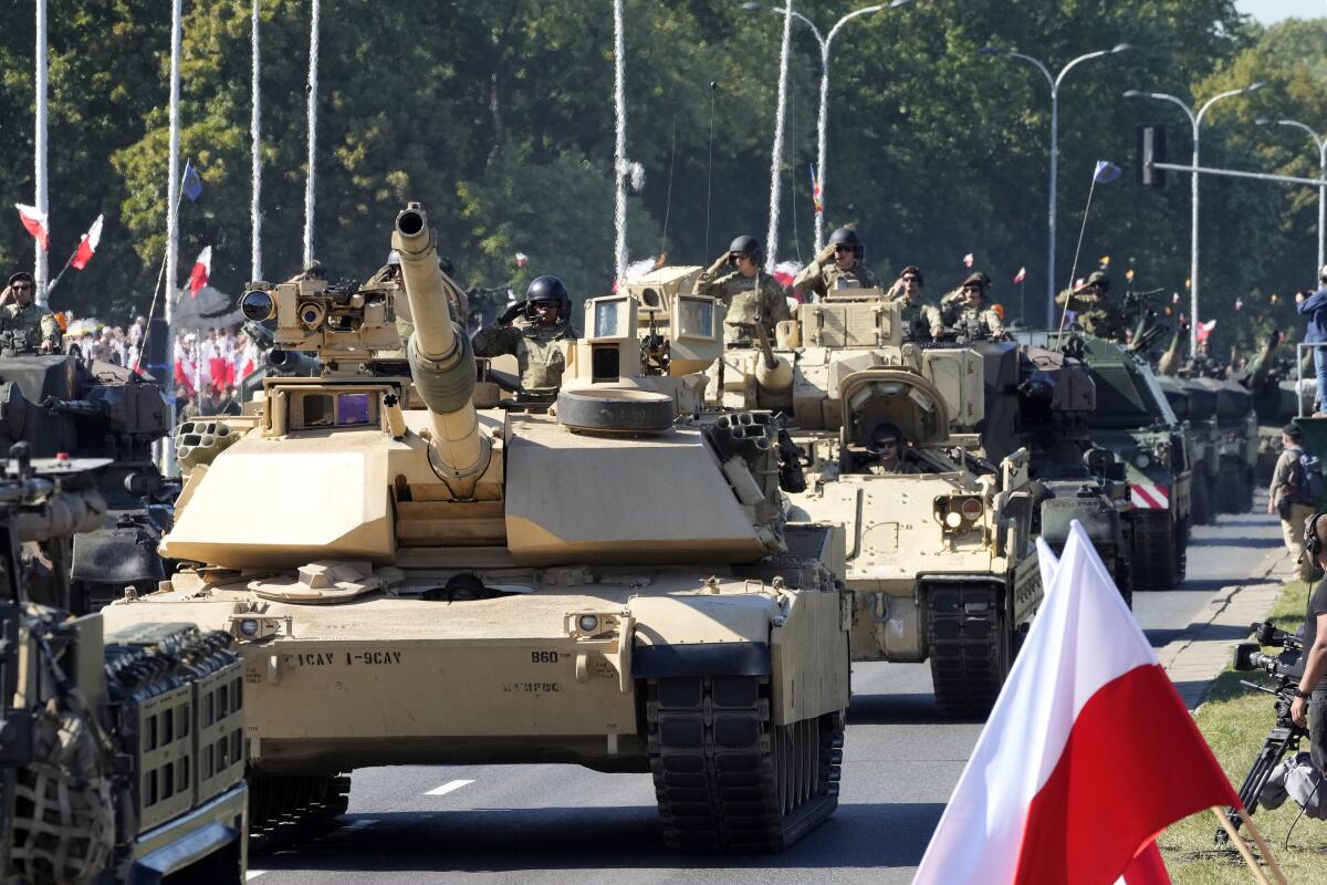 U.S.-made Abrams tanks purchased by Poland take part in a military parade in Warsaw.