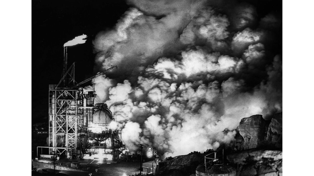 smoke billows from an industrial test site at night