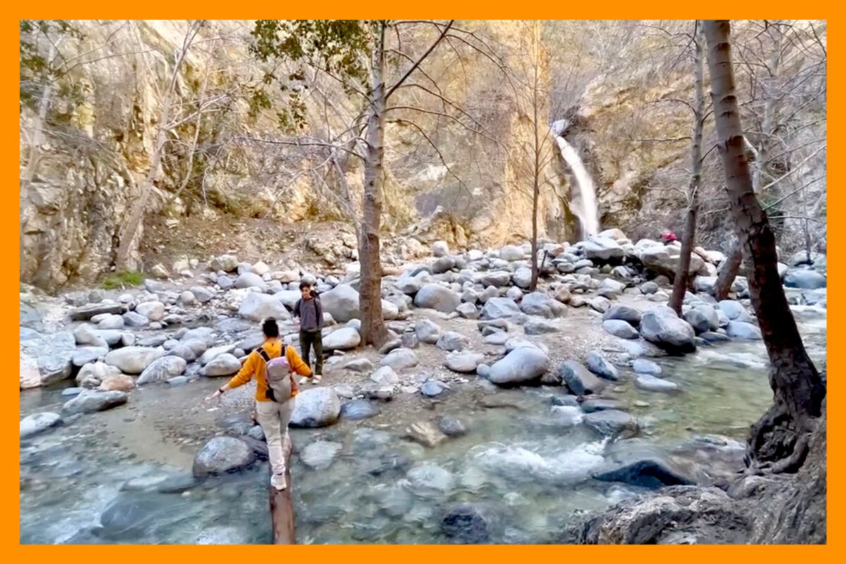 Two hikers work their way across a stream in Eaton Canyon.