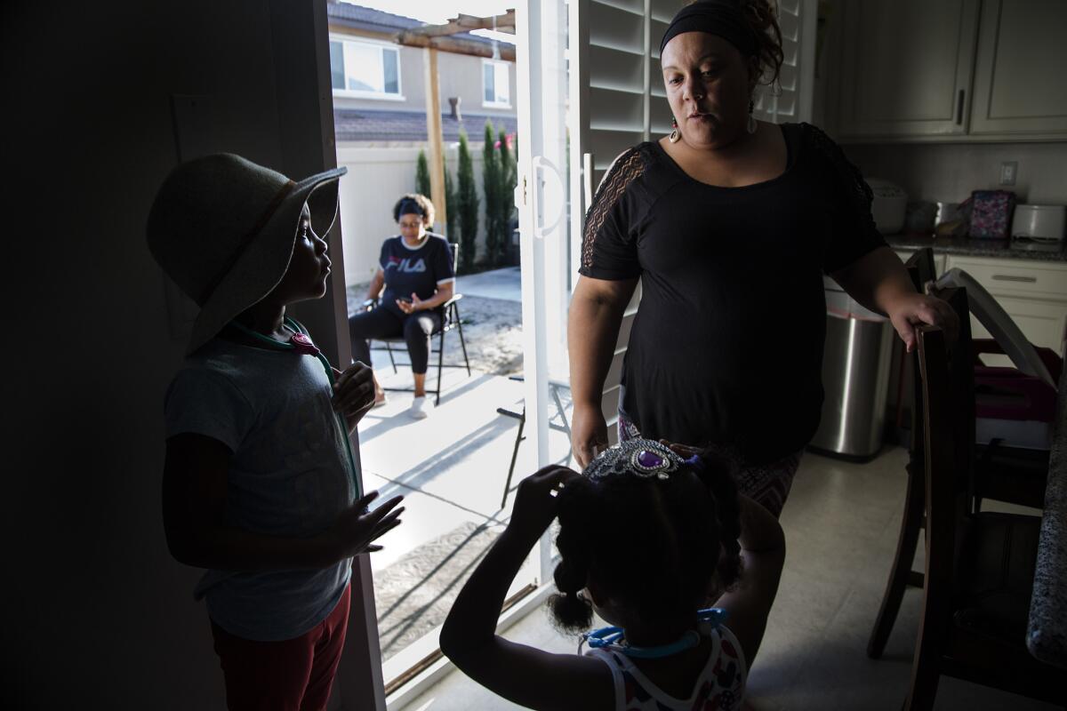 Housing manager Erica Wilson, right, spends time with Leana Wilson, 6, left, and Brooklyn Jackson, 3, before dinner at a transitional home in Eastvale that serves former offenders. (Gina Ferazzi / Los Angeles Times)