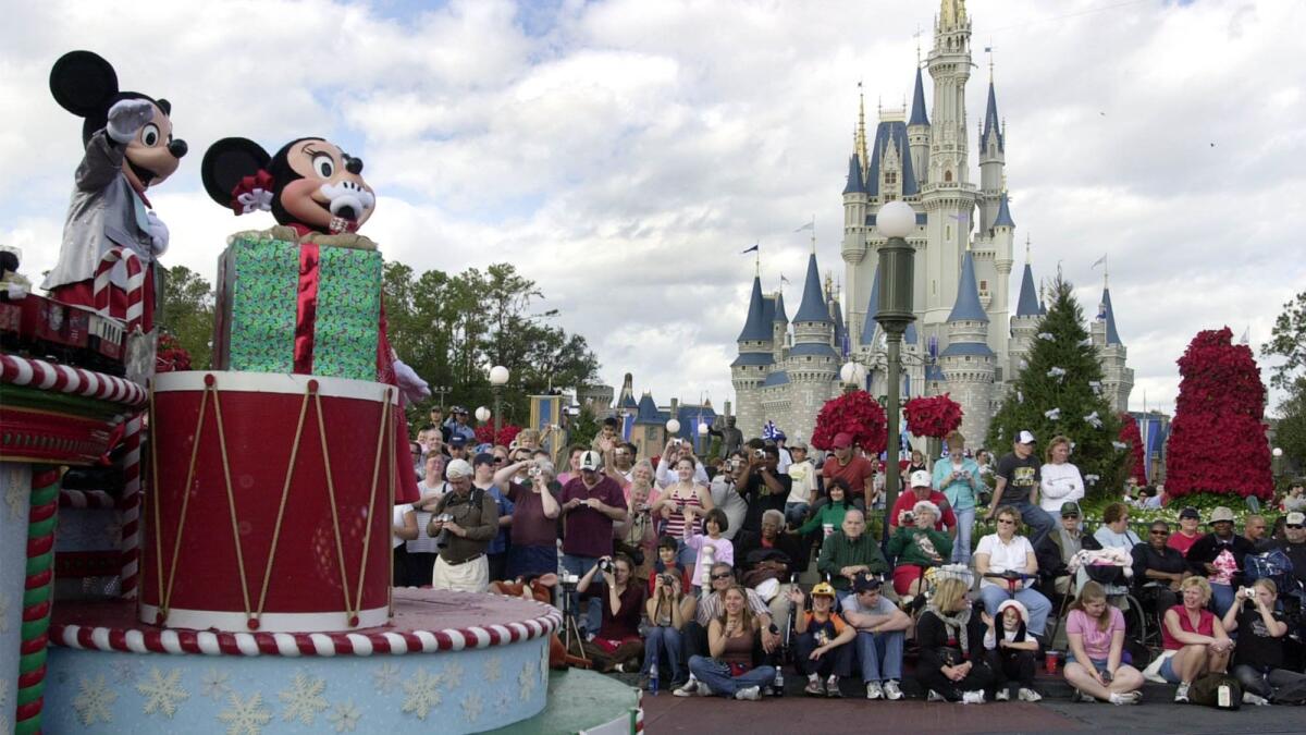 Visitors gather in front of Cinderella's castle to watch Mickey and Minnie Mouse during the Christmas parade at Walt Disney World's Magic Kingdom in Lake Buena Vista, Fla.