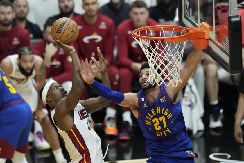 Miami Heat forward Jimmy Butler (22) drives to the basket as Denver Nuggets guard Jamal Murray (27) defends during the first half of Game 3 of the NBA Finals basketball game, Wednesday, June 7, 2023, in Miami. (AP Photo/Rebecca Blackwell)