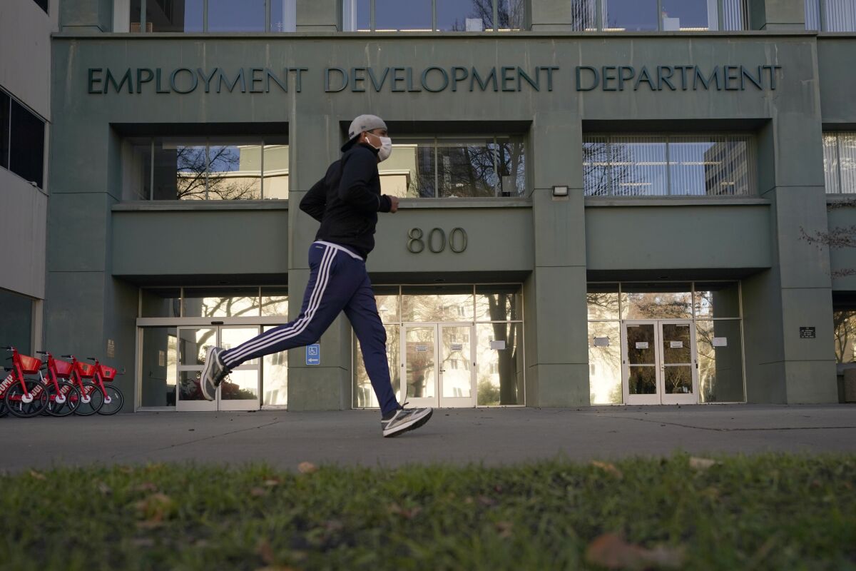 A man runs in front of the California Employment Development Department building