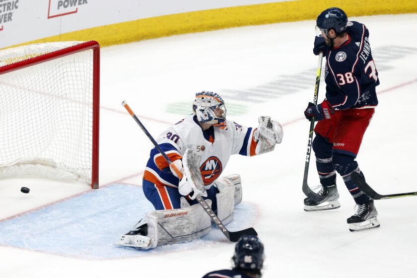Columbus Blue Jackets forward Boone Jenner, right, scores past New York Islanders goalie Ilya Sorokin during overtime in an NHL hockey game in Columbus, Ohio, Friday, March 24, 2023. The Blue Jackets won 5-4. (AP Photo/Paul Vernon)