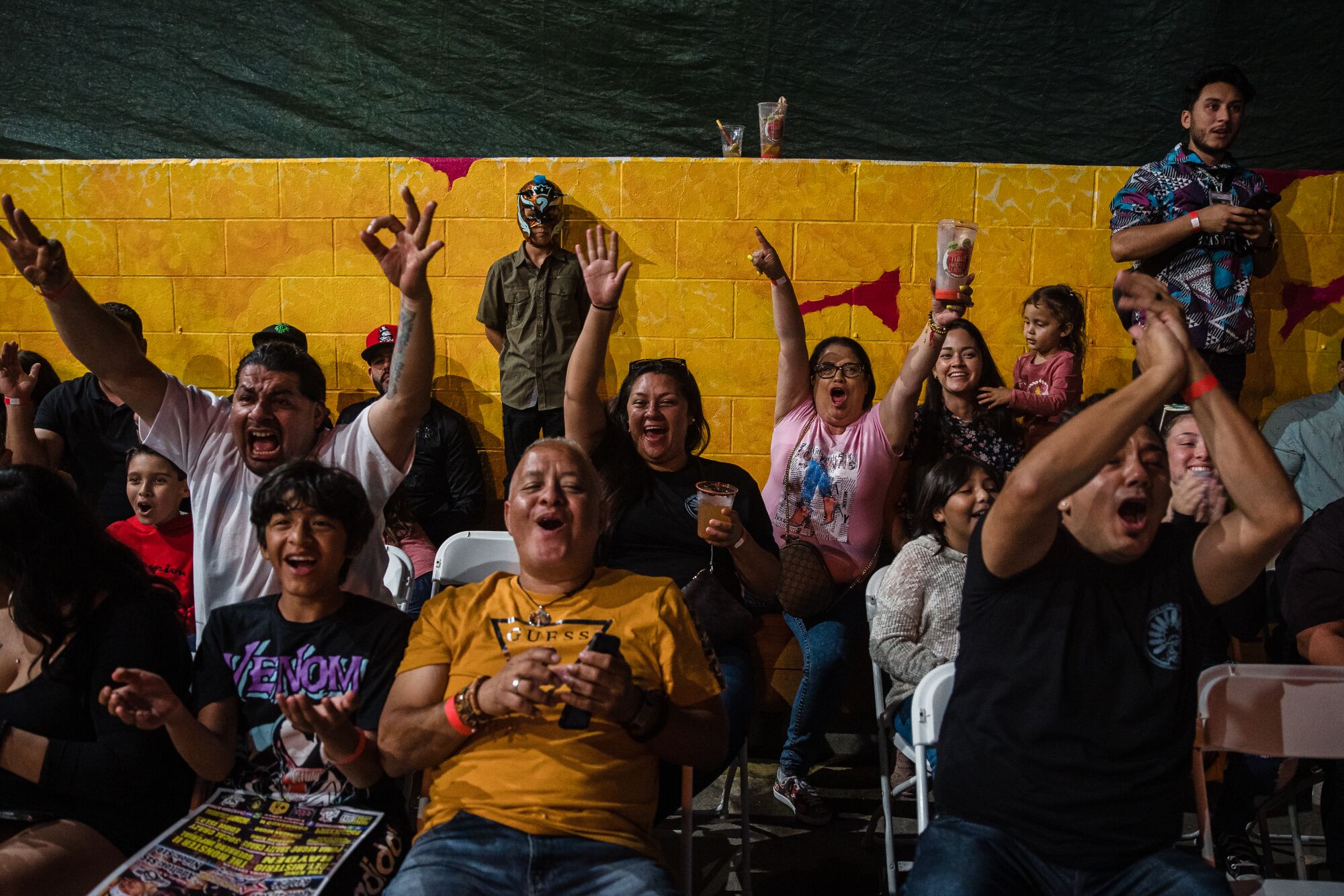 People cheer during the Baja Stars USA Lucha Libre event at the Mujeres Brew House in Logan Heights.