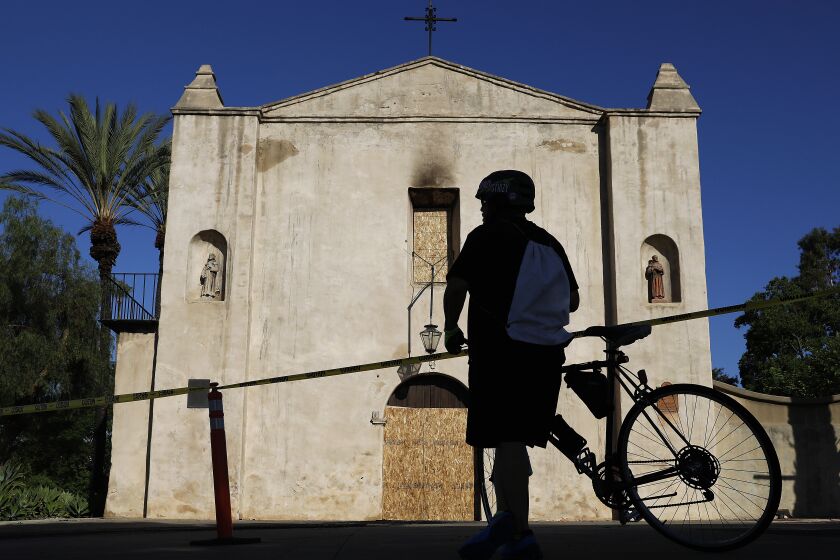 SAN GABRIEL-CA-JULY 12, 2020: A bicyclist stops in front of the historic 249-year-old San Gabriel Mission on Sunday, July 12, 2020. A fire early Saturday caused "extensive damage". (Christina House / Los Angeles Times)