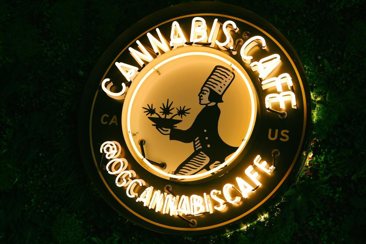 A round neon sign that reads Cannabis Cafe