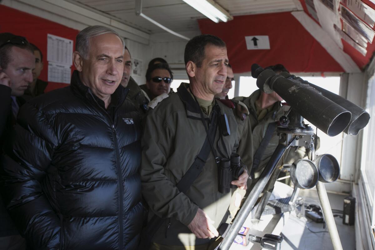 Israeli Prime Minister Benjamin Netanyahu, left, stands with Israeli soldiers during a visit to an outpost at Mt. Hermon in the Golan Heights on Wednesday.