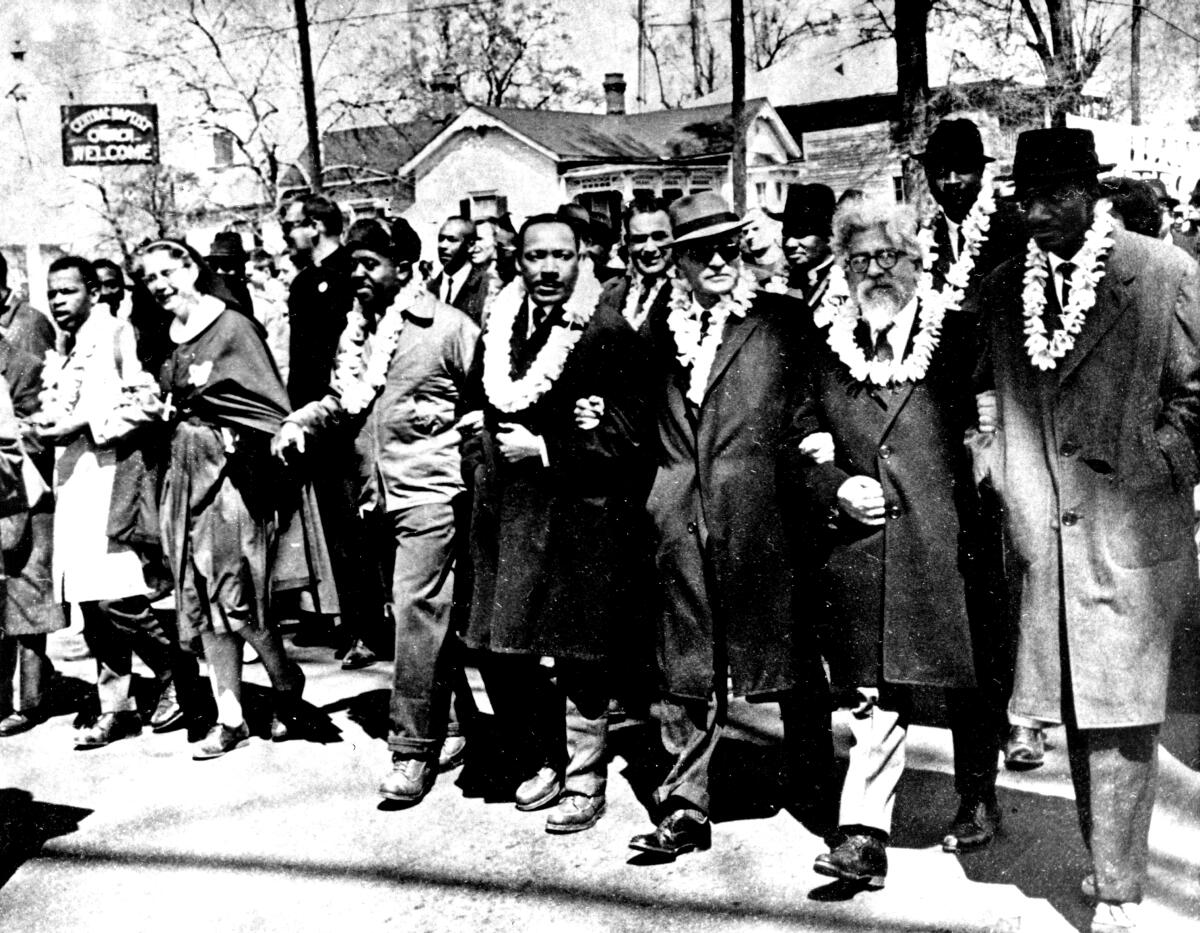 Dr. Martin Luther King Jr. links arms with civil rights leaders as they begin the march to the state capitol in Montgomery