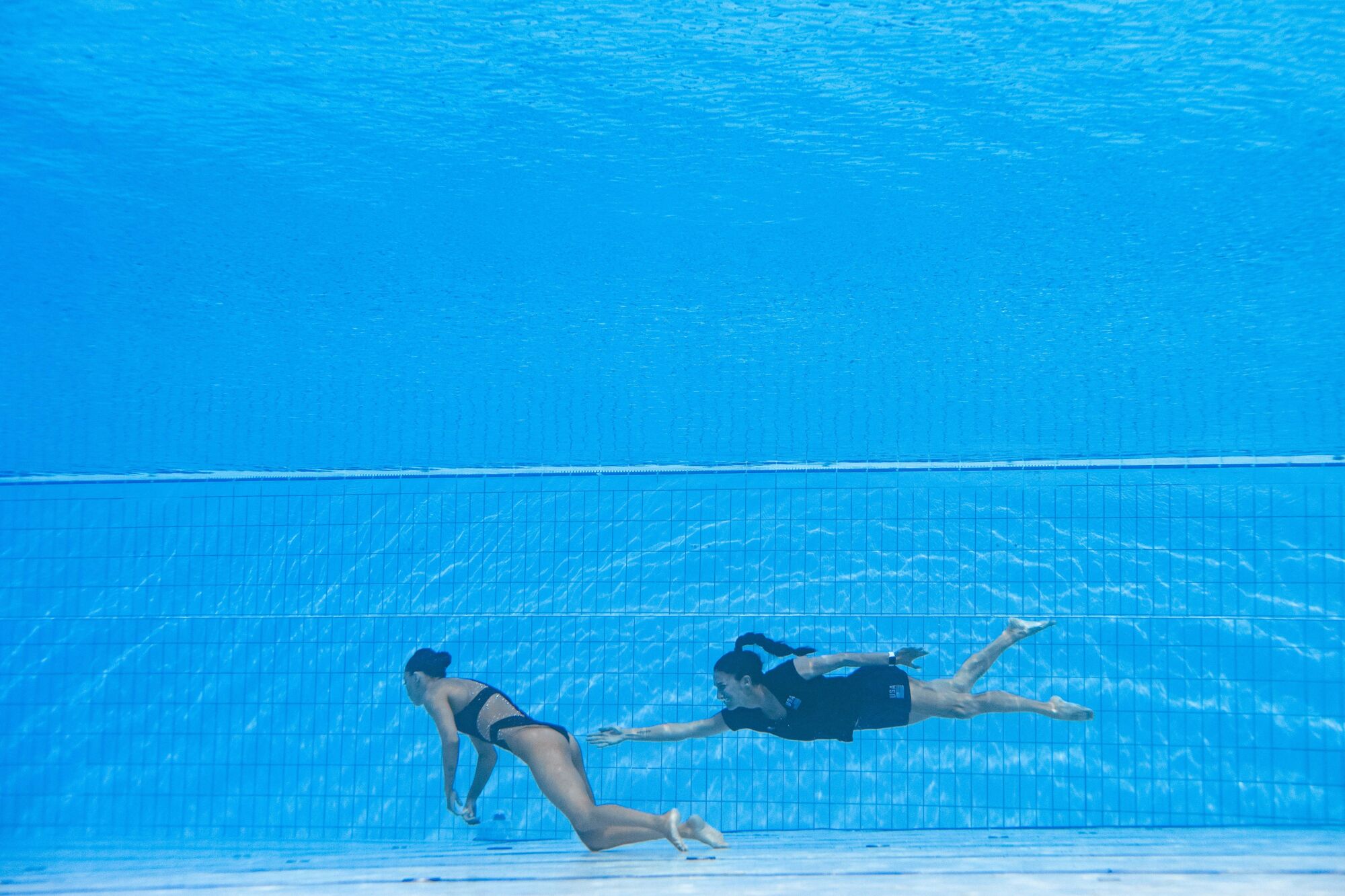 USA's coach Andrea Fuentes, right, rescues USA's Anita Alvarez from the bottom of the pool 