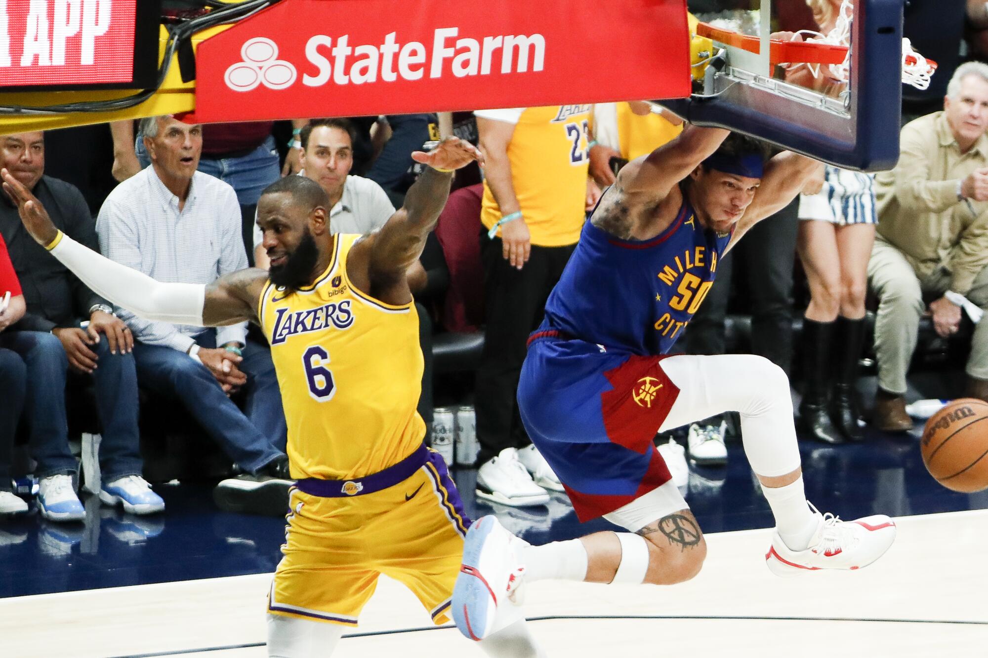 Denver Nuggets forward Aaron Gordon, right, dunks in front of Lakers forward LeBron James.