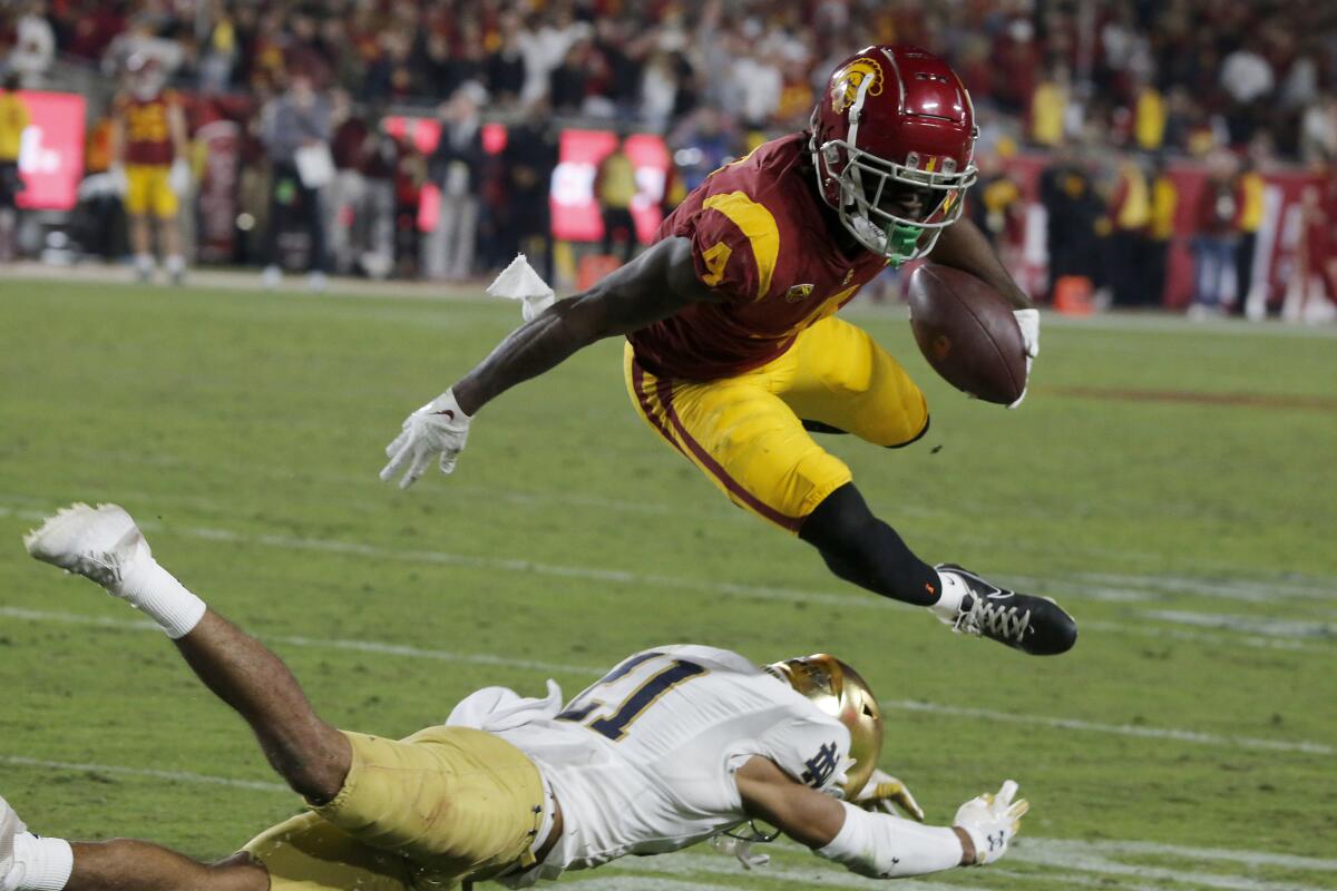 USC wide receiver Mario Williams hurdles over Notre Dame cornerback Jaden Mickey after making a catch.
