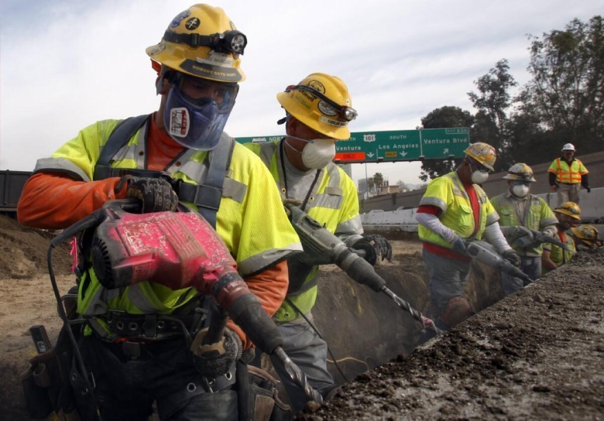 Workers drill holes in the pavement in the northbound lanes of the 405 Freeway in the Sepulveda Pass. Three of five lanes are closed during the day throughout President's Day weekend.