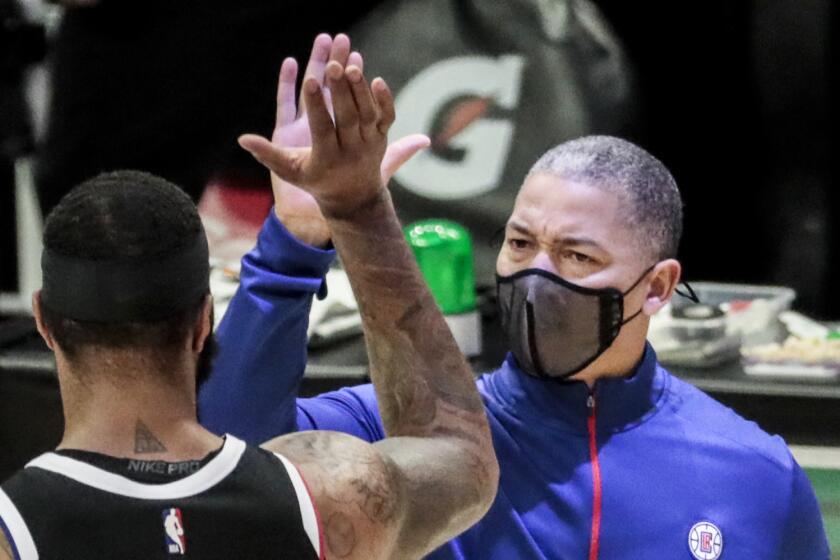 Clippers head coach Tyronn Lue high-fives forward Marcus Morris during a break in the action against the Pacers.