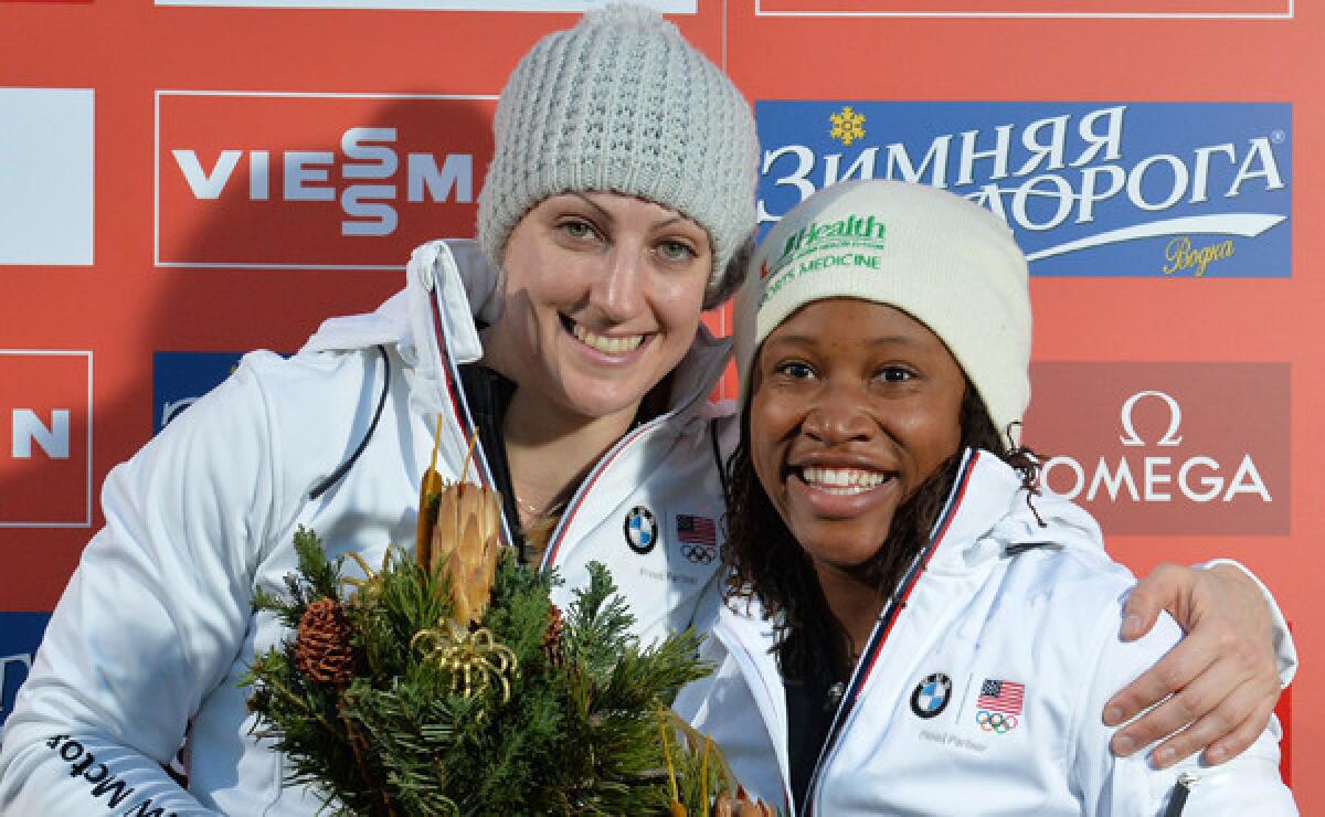 Lauryn Williams, right, and Jamie Greubel celebrate on the podium after winning a World Cup bobsled race in Innsbruck, Austria, on Sunday. Williams is set to become one of only a handful of U.S. athletes to compete in both the Summer and Winter Olympic Games.