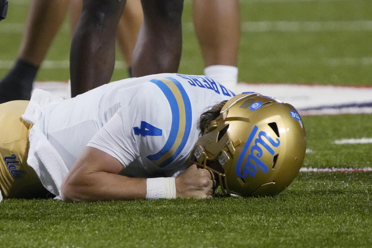 UCLA quarterback Ethan Garbers lies facedown on the field.